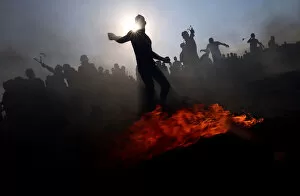 Images Dated 26th August 2018: Palestinian demonstrators hurl stones at Israeli troops during a protest at the border