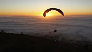 Paragliders take in the last of the days light as a seasonal fog engulfs Cape Town Paragliders take in the last of the days light as a seasonal fog engulfs Cape Town