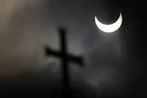 A partial solar eclipse is seen over a cross on a dome of the Alexander Nevski cathedral A partial solar eclipse is seen over a cross on a dome of the Alexander Nevski cathedral