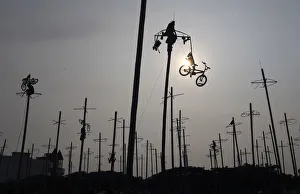 Indonesia Gallery: A participant pulls down a bicycle from the top of a greased pole during the Panjat
