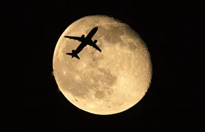 A passenger jet flies past the moon over Shanghai A passenger jet flies past the moon over Shanghai