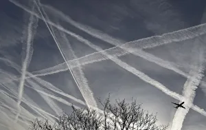 A passenger plane flies through aircraft contrails in the skies near Heathrow Airport in A passenger plane flies through aircraft contrails in the skies near Heathrow Airport in