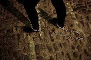 A penitent drags a chain as she takes part as penitent of Nuestro Padre Jesus Nazareno A penitent drags a chain as she takes part as penitent of Nuestro Padre Jesus Nazareno