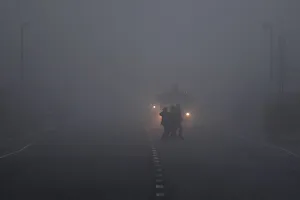 People cross a road in front of a truck in heavy fog in Belfast People cross a road in front of a truck in heavy fog in Belfast