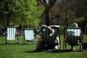 People lounge on deckchairs in the sunshine in St James Park, London People lounge on deckchairs in the sunshine in St James Park, London