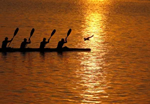 People paddle in a canoe as the sun sets over the River Ganges in Allahabad People paddle in a canoe as the sun sets over the River Ganges in Allahabad