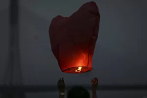 Images Dated 14th April 2014: People release paper lanterns during a celebration for the New Year of the Dai minority