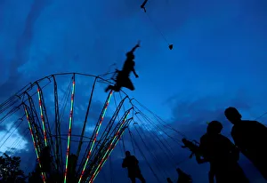 People ride on a swing carousel as part of the traditional celebration of Saint People ride on a swing carousel as part of the traditional celebration of Saint