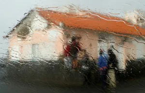 People are seen through a window as waves hit the coast of Sao Mateus in Azores People are seen through a window as waves hit the coast of Sao Mateus in Azores