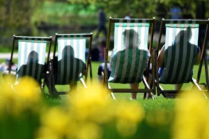 People are silhouetted against the fabric of deckchairs as they enjoy the sunshine in St People are silhouetted against the fabric of deckchairs as they enjoy the sunshine in St