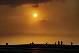 People sit along Havanas seafront boulevard El Malecon during sunset People sit along Havanas seafront boulevard El Malecon during sunset