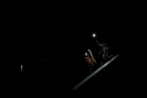 People use light from a phone while they walk on the staircase of a parking garage during People use light from a phone while they walk on the staircase of a parking garage during