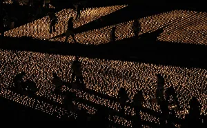 People walk amid candles lit at Praca do Comercio in Lisbon People walk amid candles lit at Praca do Comercio in Lisbon