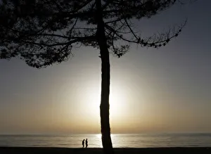 People walk along a beach facing the Adriatic sea near the city of Durres People walk along a beach facing the Adriatic sea near the city of Durres