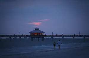 People walk along beach at twilight during the Labour Day long weekend in Ft Myers Beach People walk along beach at twilight during the Labour Day long weekend in Ft Myers Beach