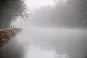 People walk along the Isar river covered in fog in Munich People walk along the Isar river covered in fog in Munich