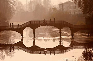 Seasons Gallery: People walk on a wooden footbridge across a canal during an autumn day in Srinagar