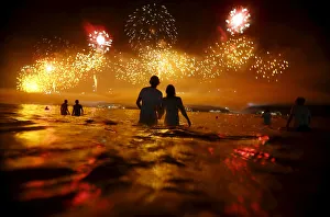 People watch as fireworks explode over Copacabana beach during New Year celebrations People watch as fireworks explode over Copacabana beach during New Year celebrations
