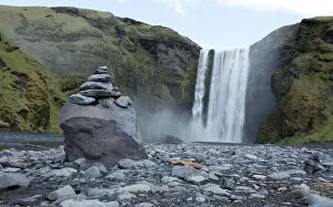 Images Dated 28th May 2011: A pile of rocks stand in front of a waterfall in Skogarfoss, Iceland