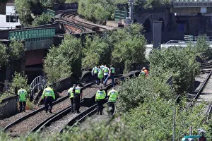 Police officers search near to where three people were found dead on a section railway Police officers search near to where three people were found dead on a section railway