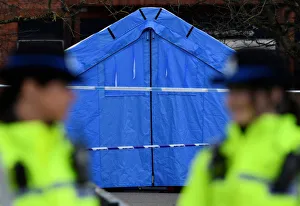Police officers stand guard in front of a forensics tent in a cordoned off area in the Police officers stand guard in front of a forensics tent in a cordoned off area in the