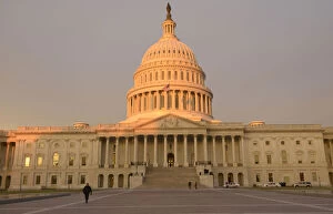 Images Dated 21st January 2013: Policeman walks at plaza on East front of U.S. Capitol as the sun rises in the early dawn