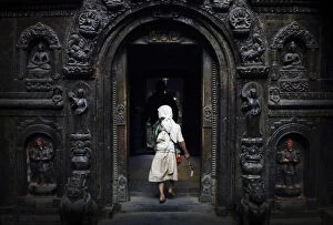 A priest enters the premises of a temple to offer daily prayers in Lalitpur
