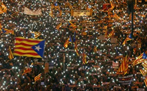 Protesters hold the lights of their mobile phones as they wave Estelada flags during a Protesters hold the lights of their mobile phones as they wave Estelada flags during a