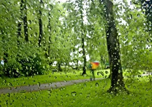 Raindrops are pictured on a car windscreen as person walks in a park on a rainy day Raindrops are pictured on a car windscreen as person walks in a park on a rainy day