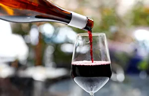 Red wine is poured in a glass in a wine shop in Rome Red wine is poured in a glass in a wine shop in Rome