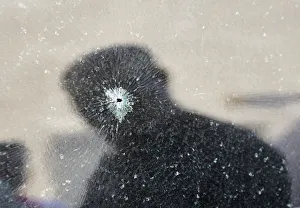 The reflection of a man is seen on a shattered car windscreen after a bomb blast in the The reflection of a man is seen on a shattered car windscreen after a bomb blast in the