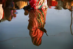 The reflection of a woman is seen in the waters of the Sabarmati River as she worships The reflection of a woman is seen in the waters of the Sabarmati River as she worships