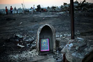 A religious image is seen in front of debris of an immigrants shacks camp after an A religious image is seen in front of debris of an immigrants shacks camp after an