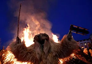 A reveller wearing a mask dances near a bonfire during the traditional Buso Carnival in A reveller wearing a mask dances near a bonfire during the traditional Buso Carnival in