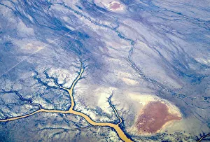 River systems can be seen flowing near sand dunes in outback Queensland River systems can be seen flowing near sand dunes in outback Queensland
