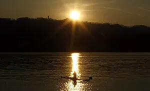 Images Dated 28th March 2012: A rower is seen during sunset on Lake Zurich on a mild and sunny spring day near Kuesnacht