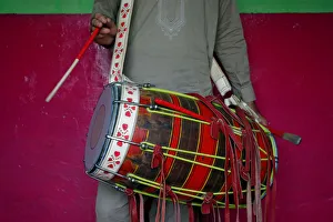 Safeer strikes a dhol, an Indian musical instrument, as he practises in his room in Safeer strikes a dhol, an Indian musical instrument, as he practises in his room in