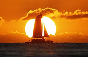 A sail boat passes in front of the sun as the last rays of sunlight of 2011 hit the A sail boat passes in front of the sun as the last rays of sunlight of 2011 hit the