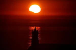 The Saint-They Chapel is seen in silhouette at sunset during a partial solar eclipse as The Saint-They Chapel is seen in silhouette at sunset during a partial solar eclipse as