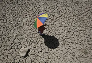 A schoolgirl crosses a dry pond on the outskirts of Jammu A schoolgirl crosses a dry pond on the outskirts of Jammu