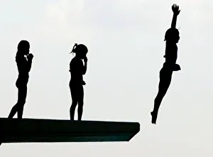 Schoolgirls dive from a five-metre platform at a swimming pool in Oiso Schoolgirls dive from a five-metre platform at a swimming pool in Oiso