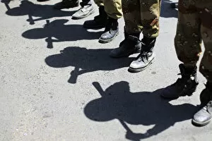 Images Dated 6th October 2011: Shadows of army soldiers holding batons are cast on the ground as they stand in line to