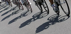 Shadows are cast on the road as the pack of riders cycles during the twelfth stage