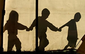 Images Dated 14th January 2009: The shadows of children walking hand in hand are seen on a tent at a temporary refuge