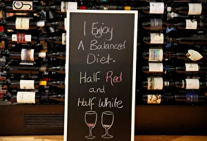 A sign is seen in front of bottles of wine being sold at a retail store at Sydney A sign is seen in front of bottles of wine being sold at a retail store at Sydney