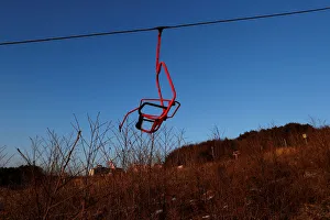 A ski lift chair hangs at the abandoned Alps Ski Resort located near the demilitarized A ski lift chair hangs at the abandoned Alps Ski Resort located near the demilitarized