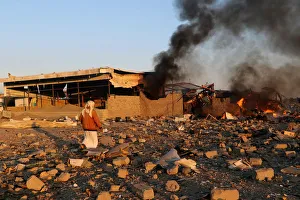 Smoke rises as people inspect damage at the site of air strikes in the city of Saada Smoke rises as people inspect damage at the site of air strikes in the city of Saada