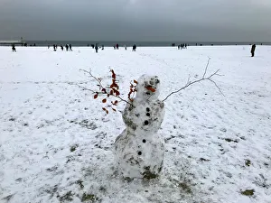 A snowman is seen as people stroll on a snow-covered beach in Gdynia A snowman is seen as people stroll on a snow-covered beach in Gdynia