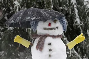A snowman with an umbrella is covered in ice in a Renton, Washington neighborhood A snowman with an umbrella is covered in ice in a Renton, Washington neighborhood