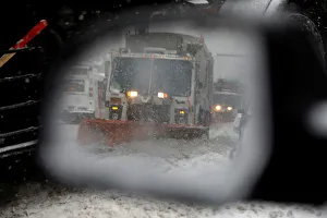 A snowplow is seen in a cars side mirror in upper Manhattan during Storm Grayson in New A snowplow is seen in a cars side mirror in upper Manhattan during Storm Grayson in New